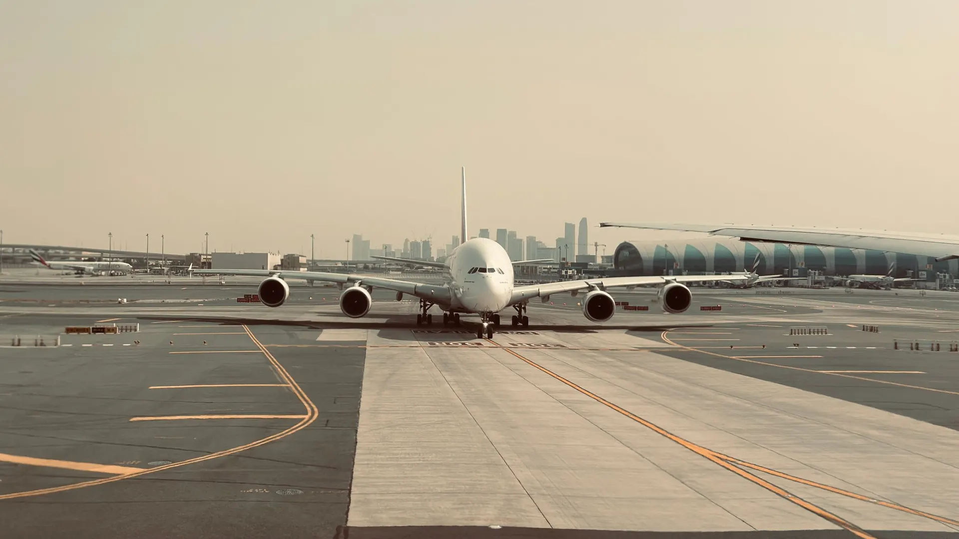 Large airliner on the apron at Dubai International Airport with the city skyline in the distance